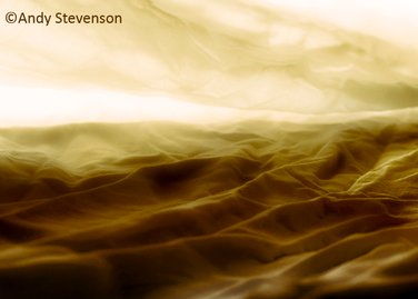 Abstract image by Andy Stevenson of what it looks like a view from above of mountains or  yellowish waves.
